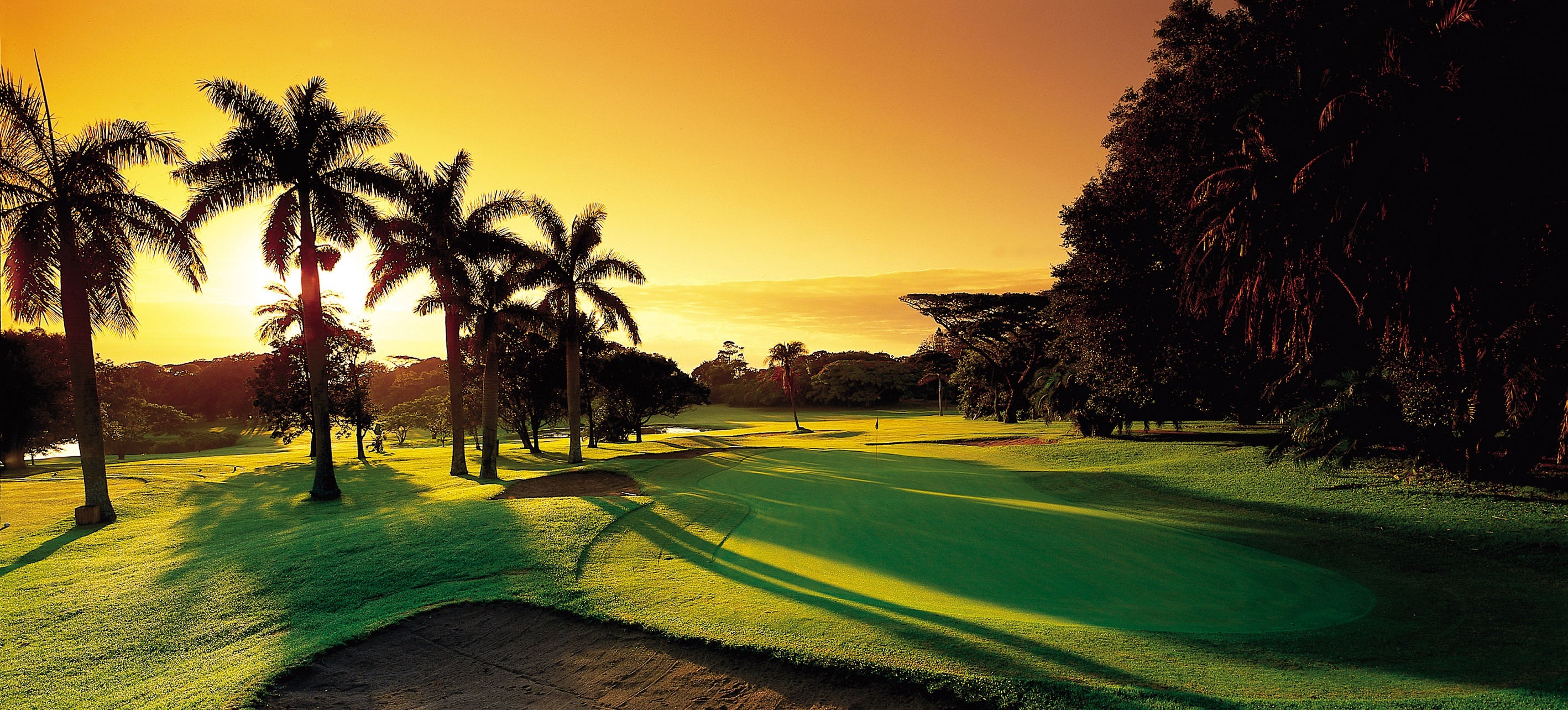 Fancourt clubhouse at sunset and the 18th hole with the Outeniqua mountains as a backdrop